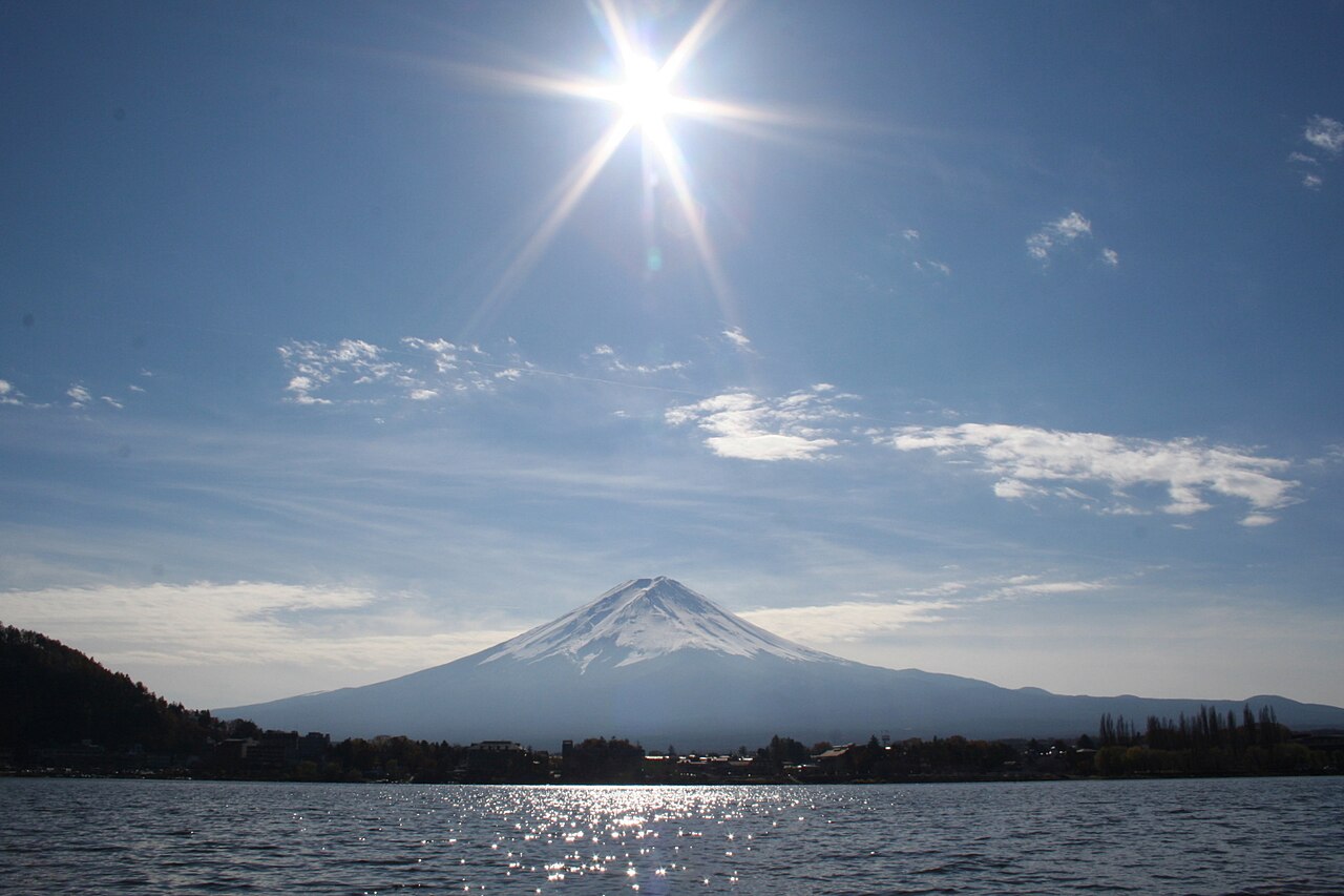 从河口湖看雪顶富士山，阳光照在湖面上。